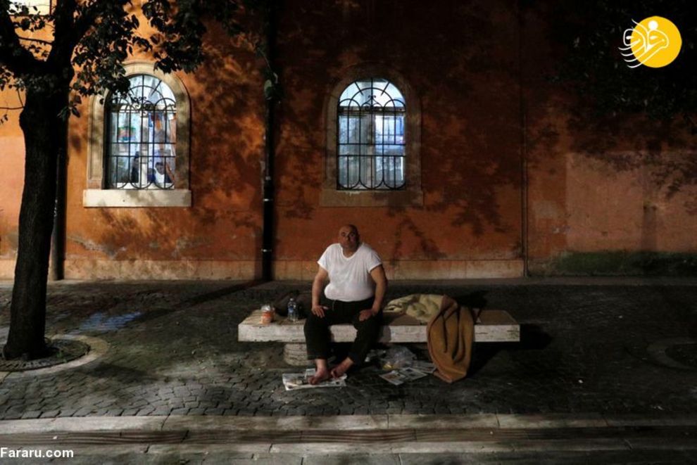 یک مرد بی خانمان نشسته روی نیمکت در رم ایتالیا