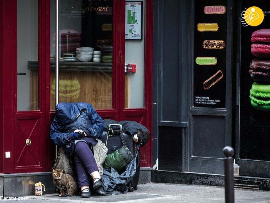 یک مرد بی خانمان با گربه اش در خیابانی در پاریس فرانسه